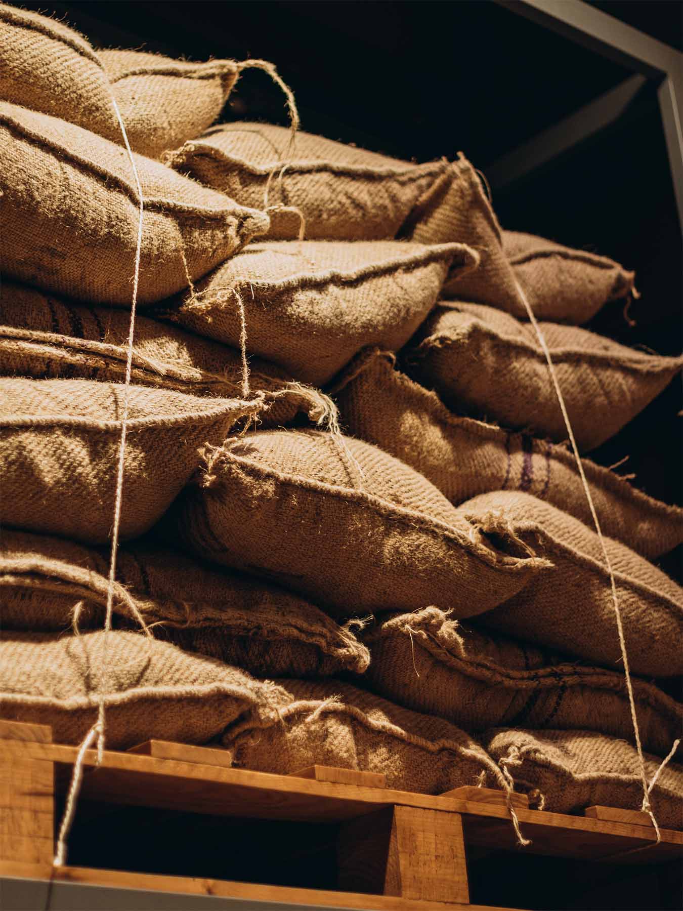 Lagerraum mit gestapelten Kakaobohnen-Säcken aus grober Jute