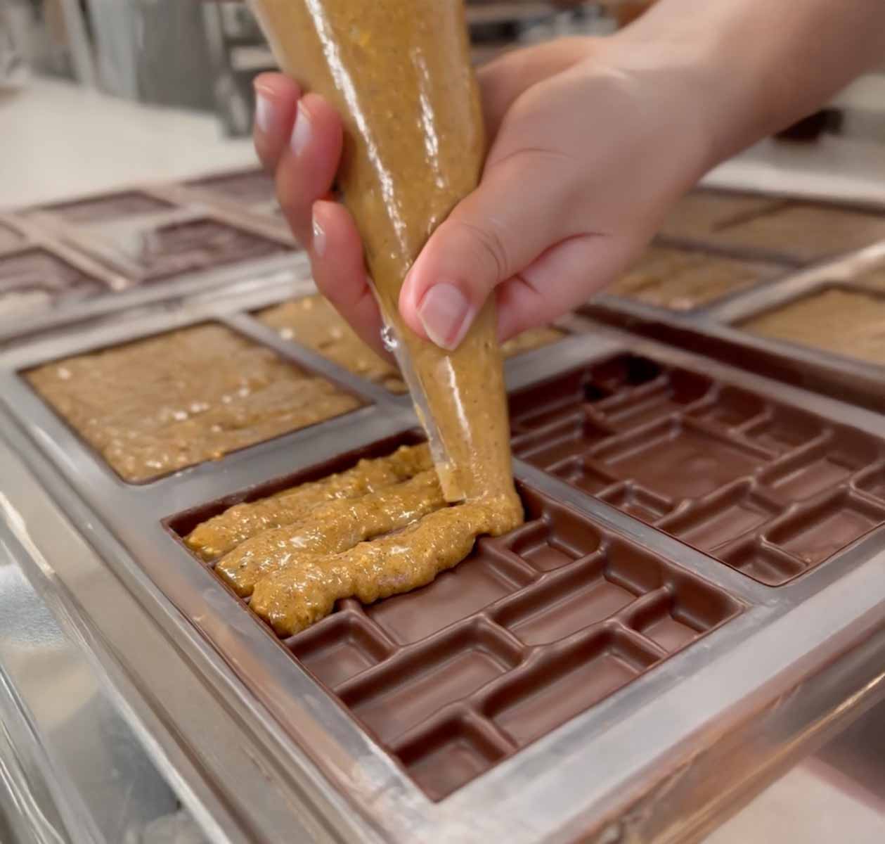 Das Füllen unserer LABRIQ Schokoladentafeln mit knusprigem Nuss-Praliné