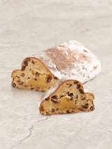 Angeschnittener Weihnachtsstollen mit Puderzucker, Marzipankern und Rosinen